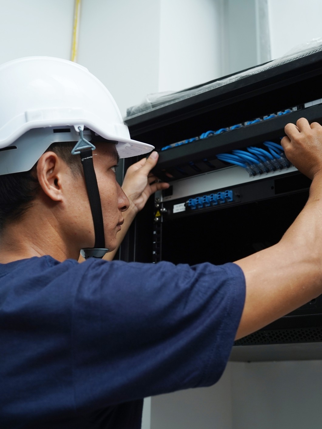 technician working wiring components for a data center