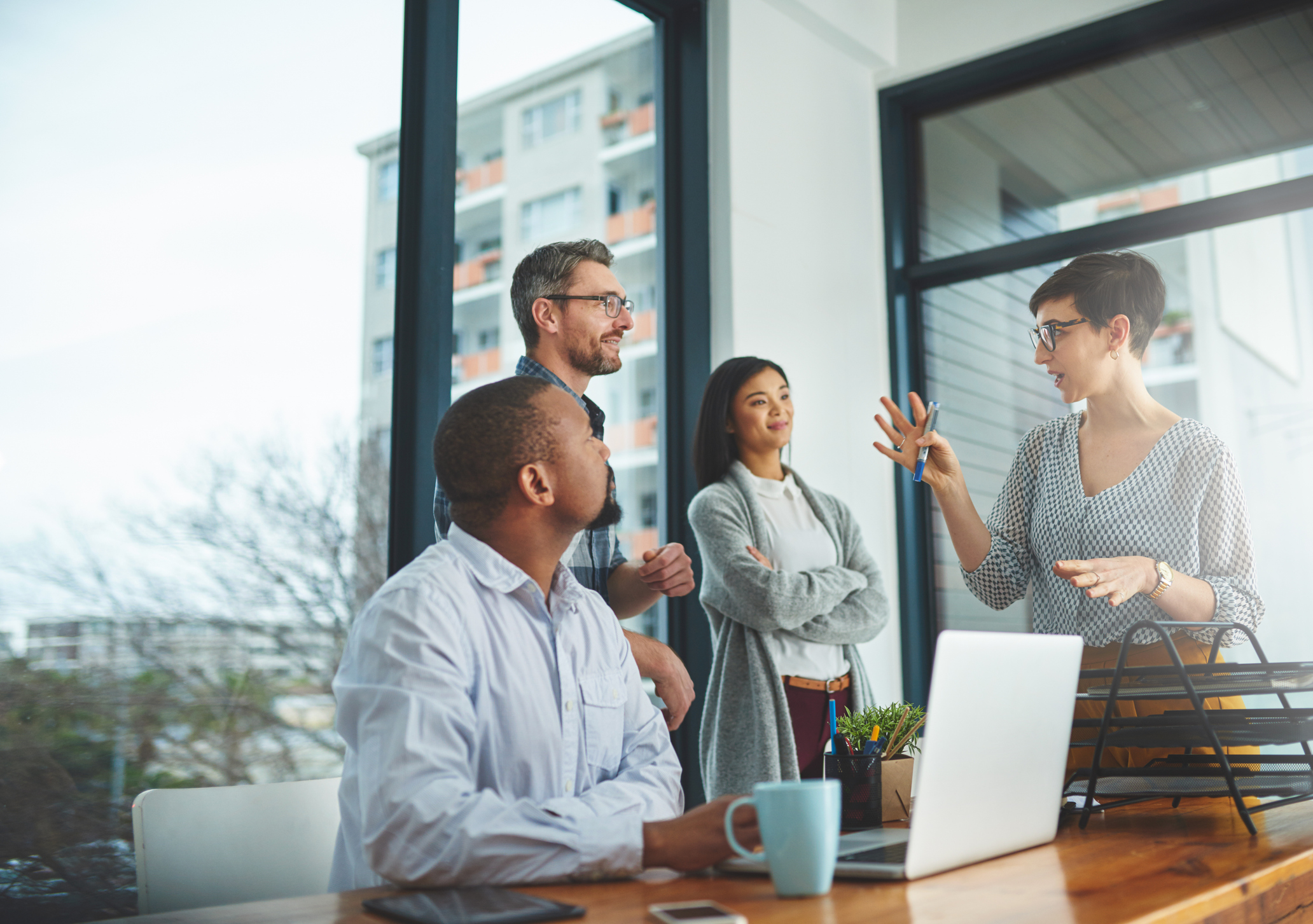 Three employees in an office overlooking paperwork on the desk