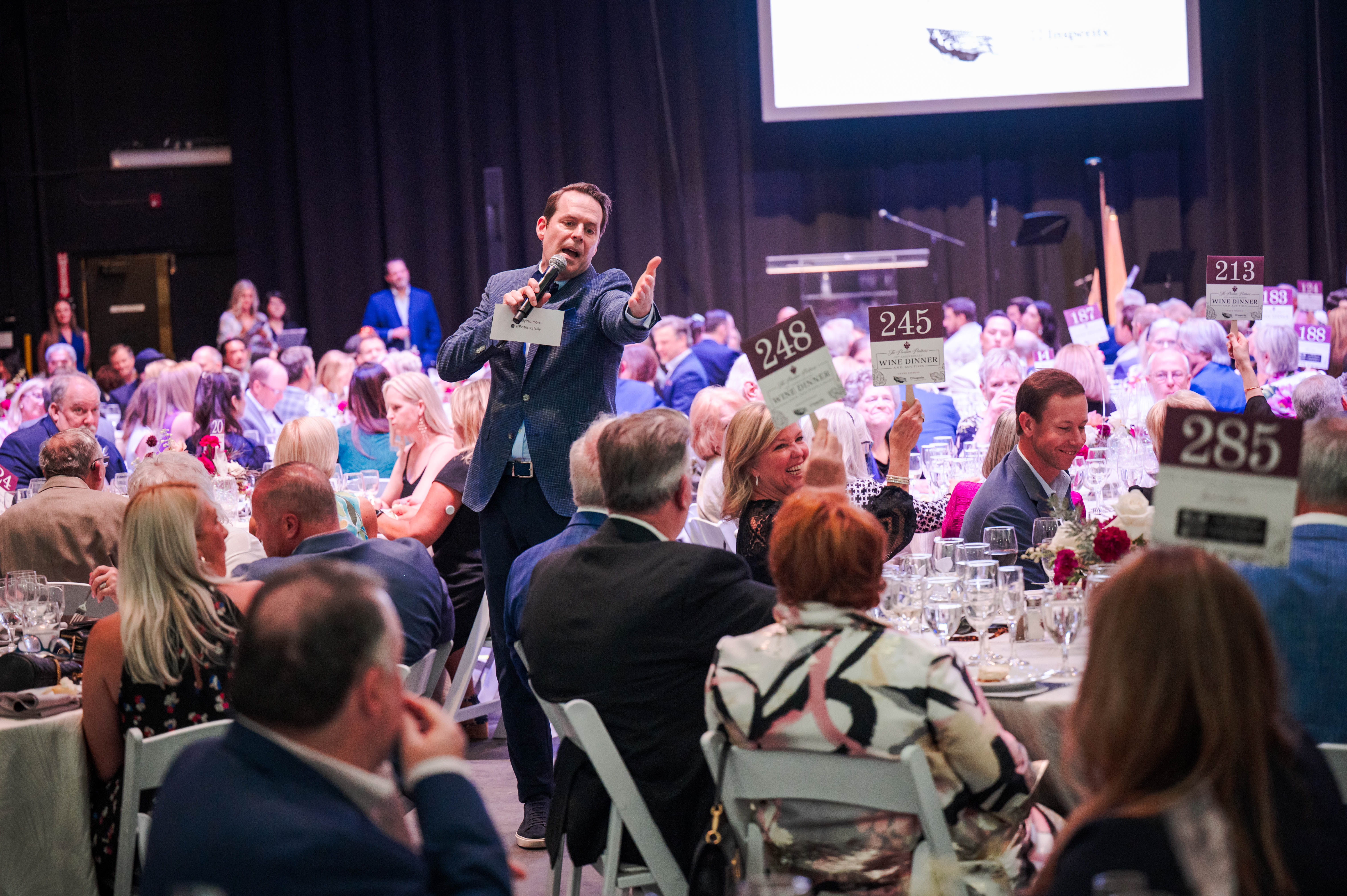 Guests participate in the auction at a previous Wine Dinner