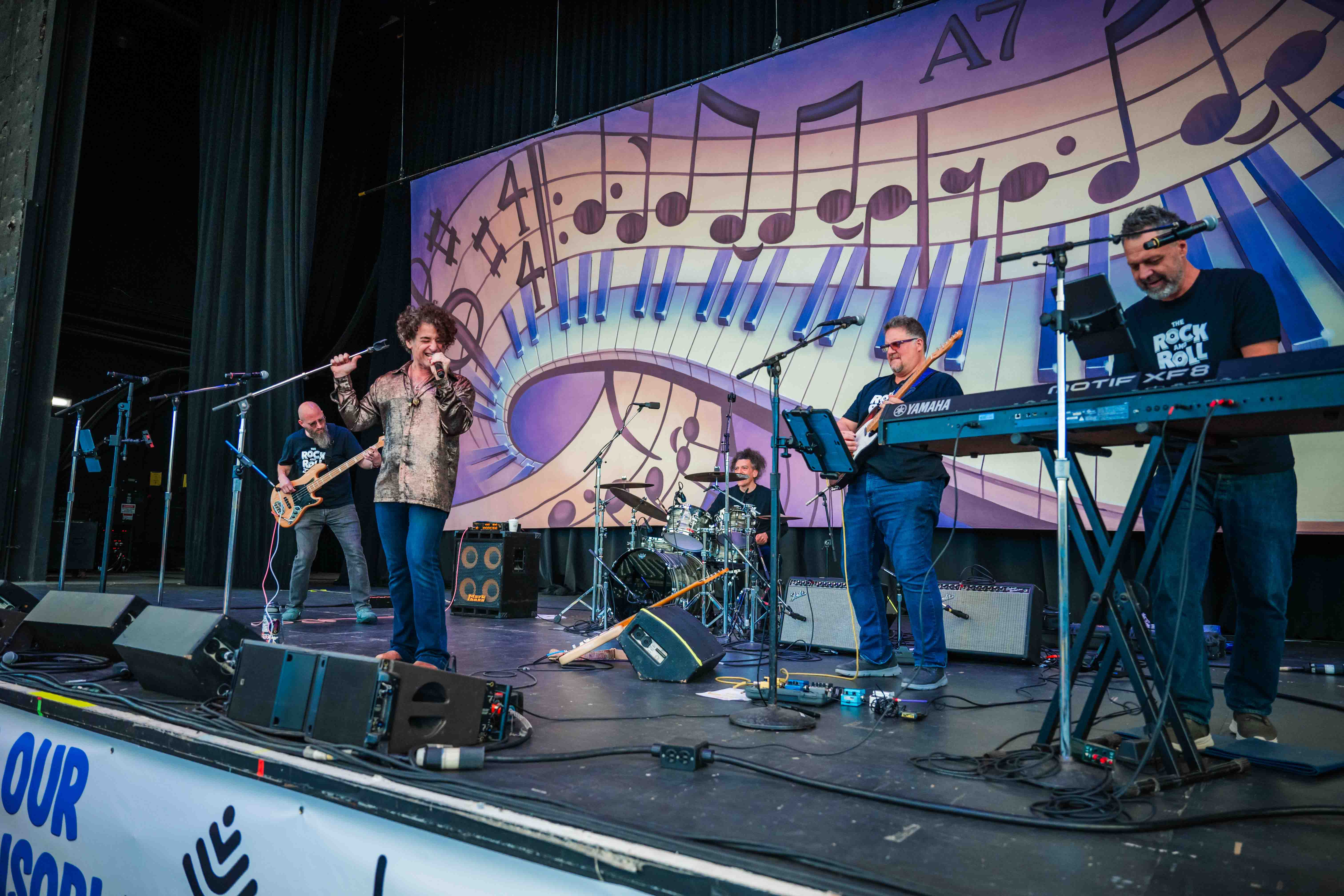A family crowd watches a live band perform on the Main Stage.
