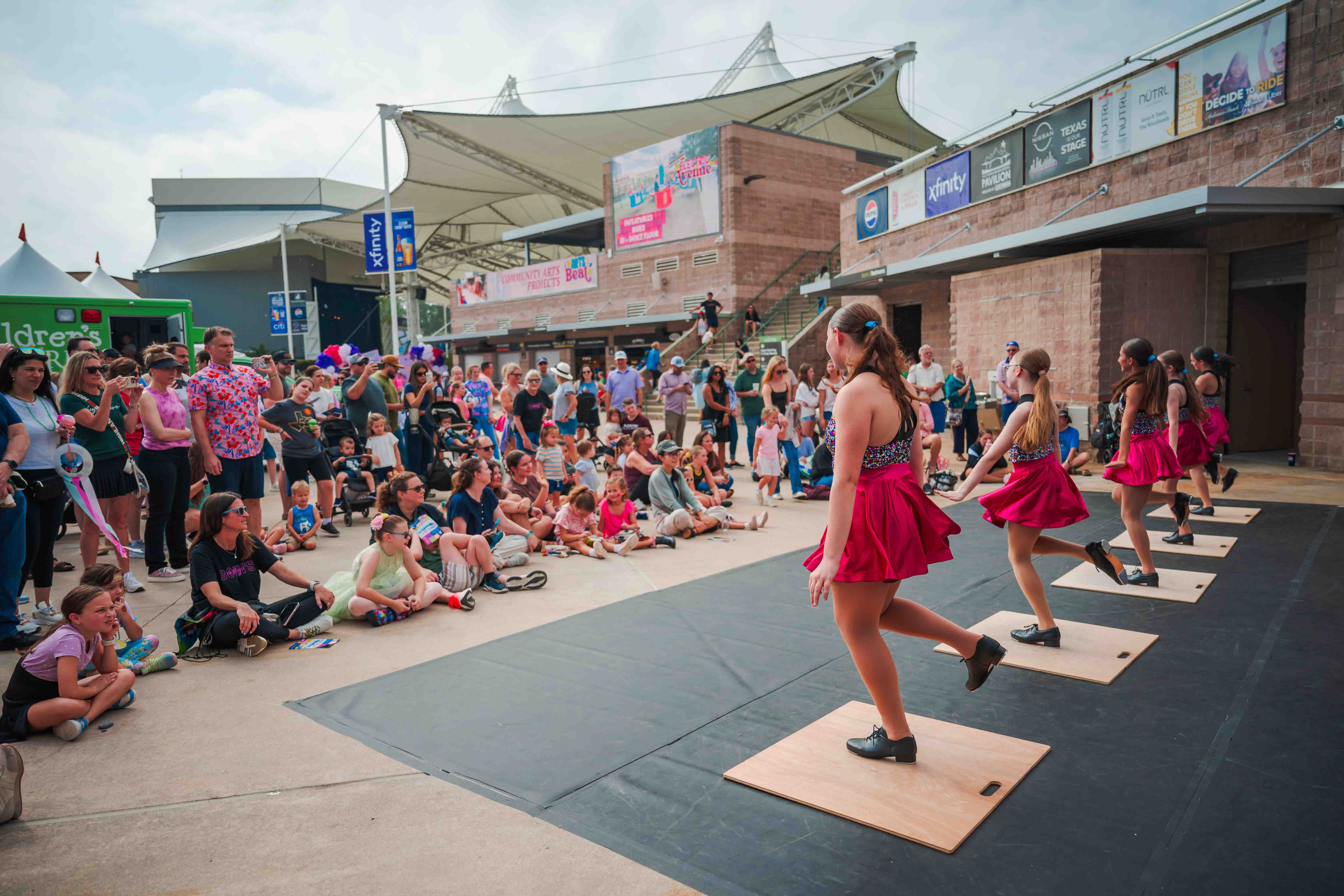 Young guests dance along with performers during a colorful festival show.