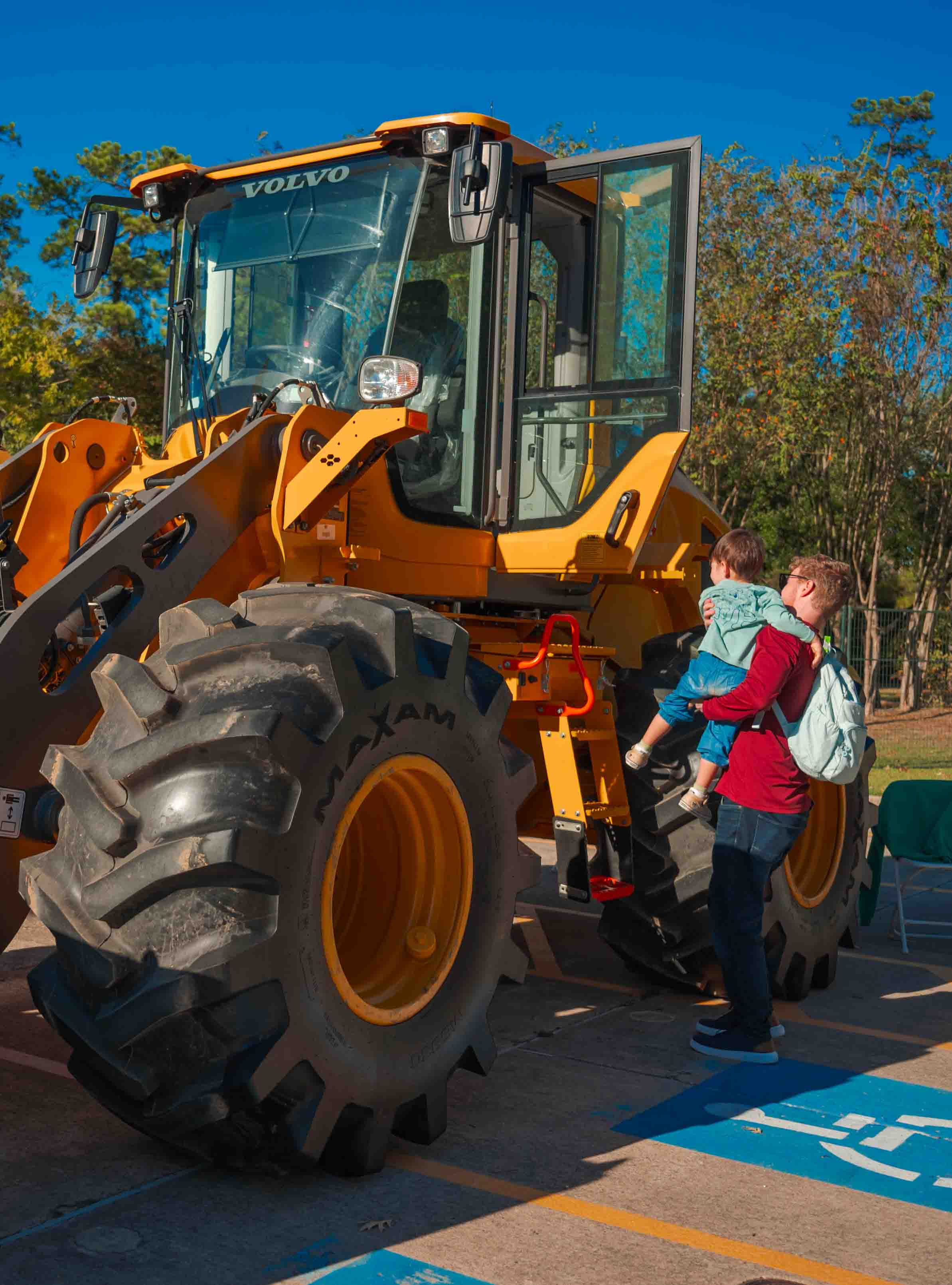 Festival volunteers gather around a large green tractor.