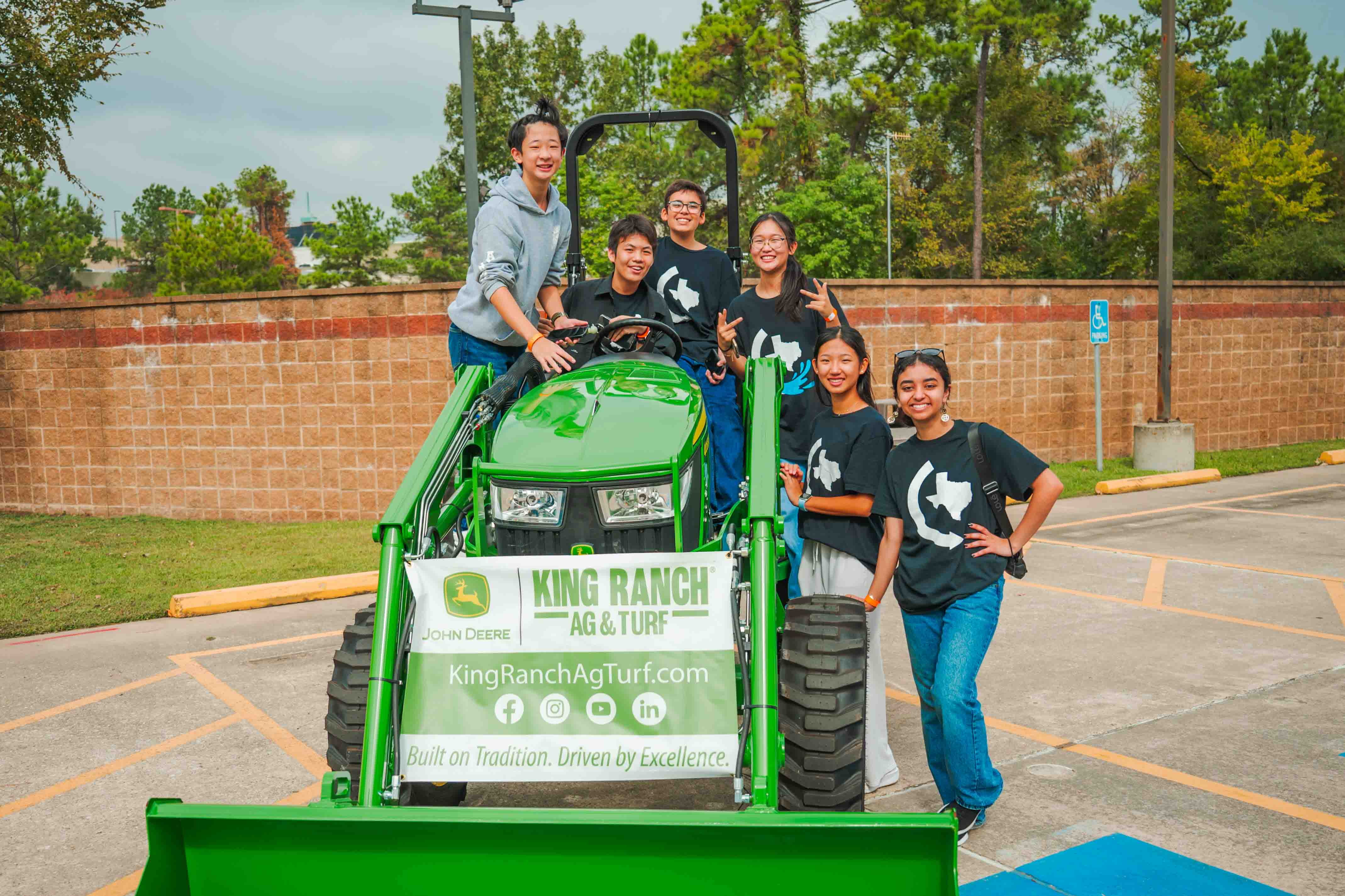 Festival volunteers gather around a bright green tractor.