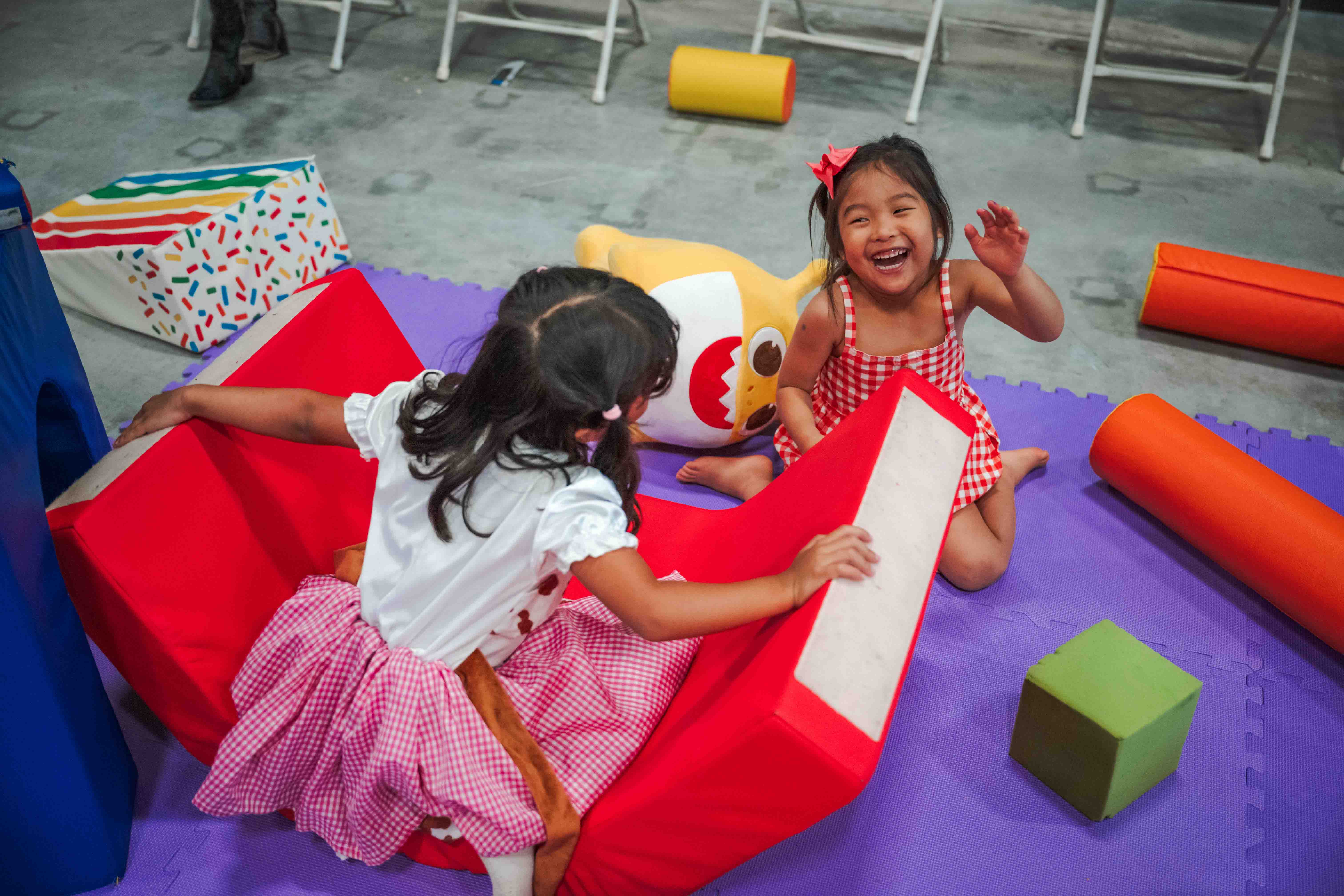Toddlers dance and play together near a family performance.