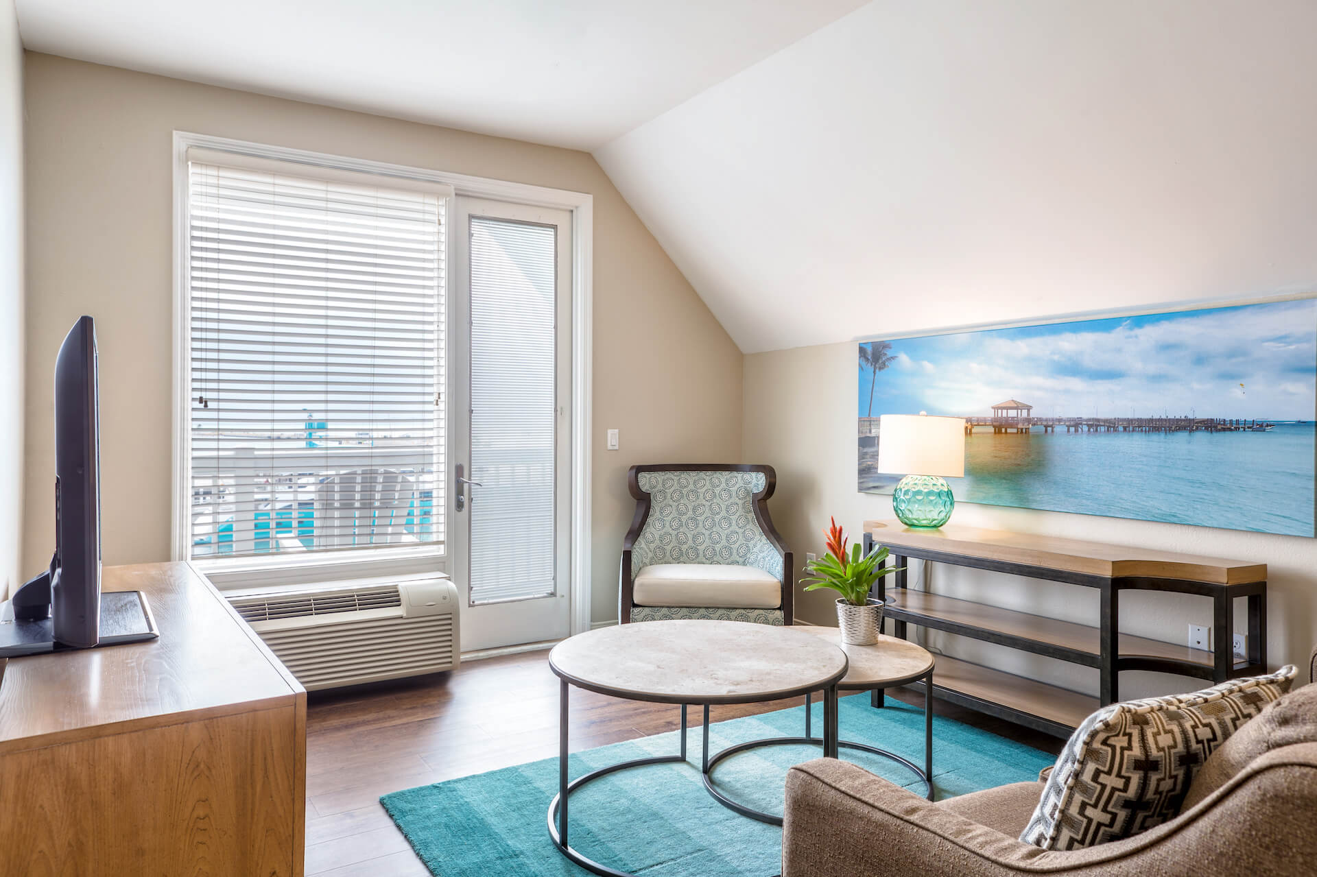 Room with sofa, armchair, TV and large window