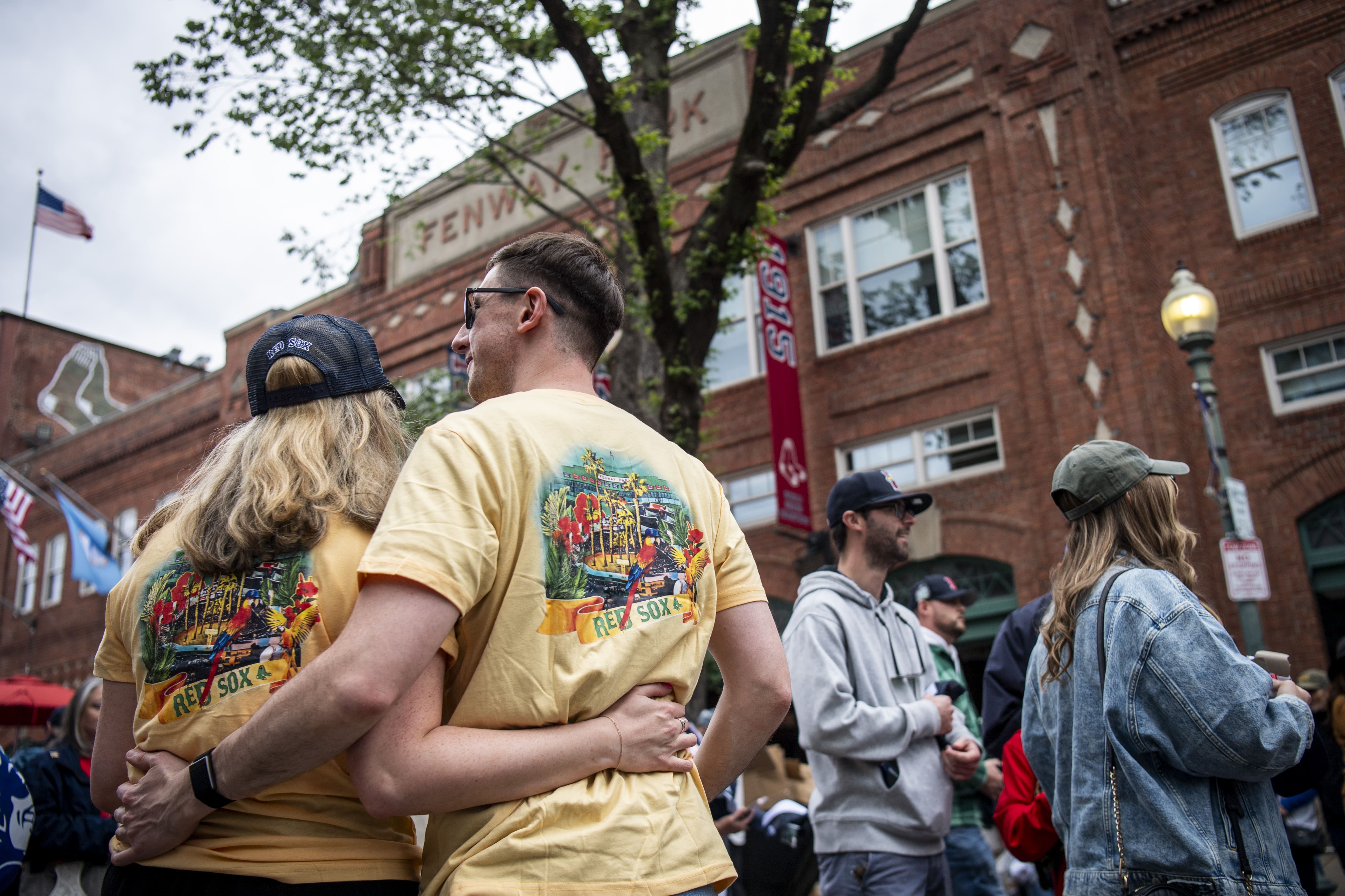 Fans at Fenway Park posing in matching yellow Red Sox shirts
