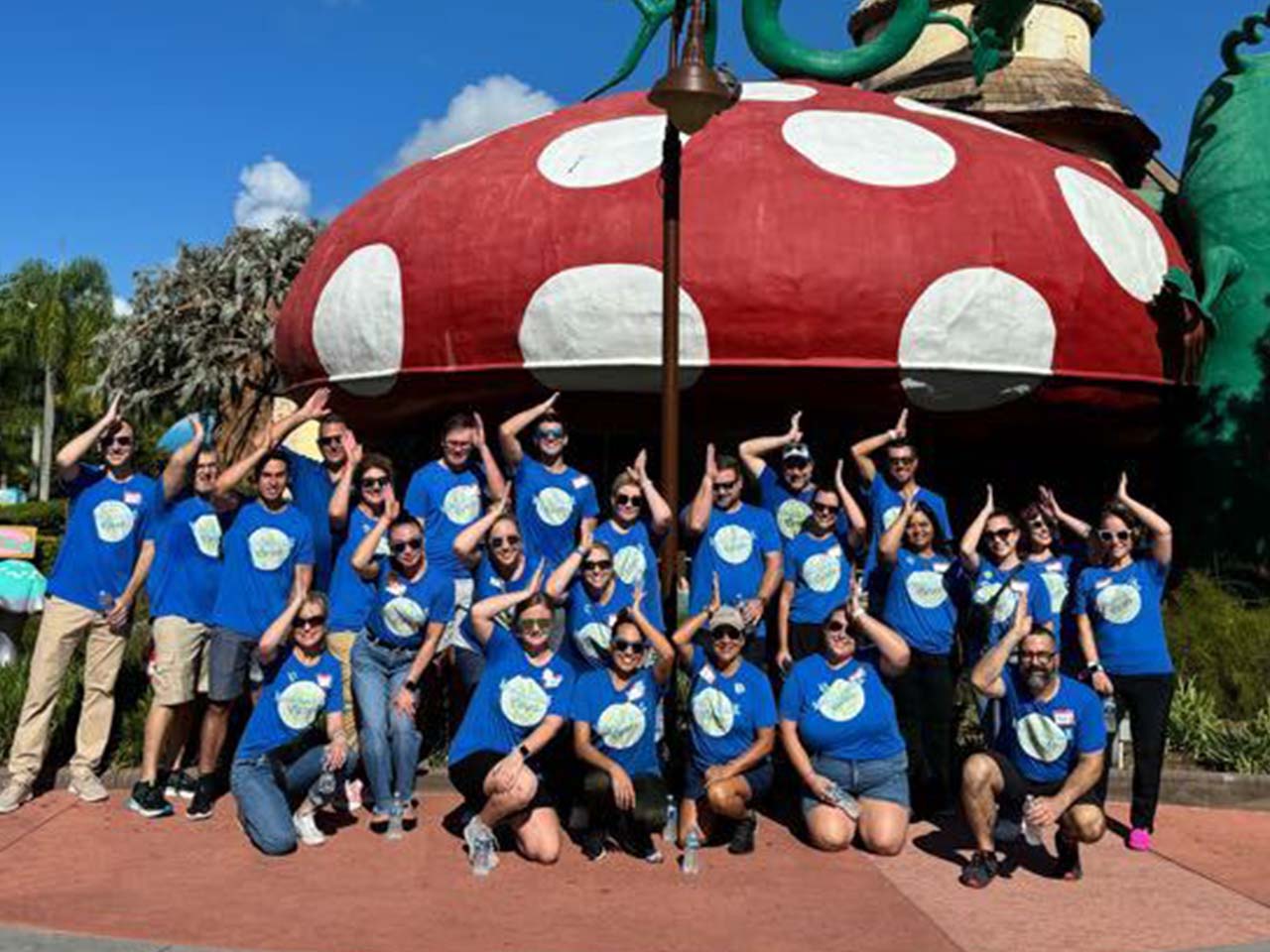 Give Kids the World Village team smiling with fins up hand gesture