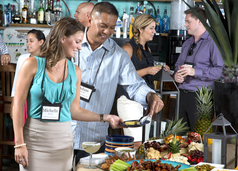 Man and woman are standing at the table with food
